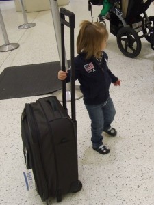 a little girl holding a suitcase