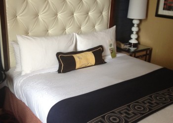 a bed with a white headboard and a black and white pillow