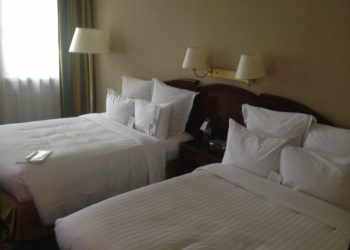 two beds with white sheets and pillows