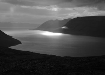 a body of water with mountains in the background