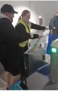 a man in a yellow vest holding a piece of paper