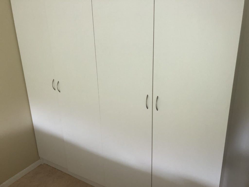 a white closet with silver handles