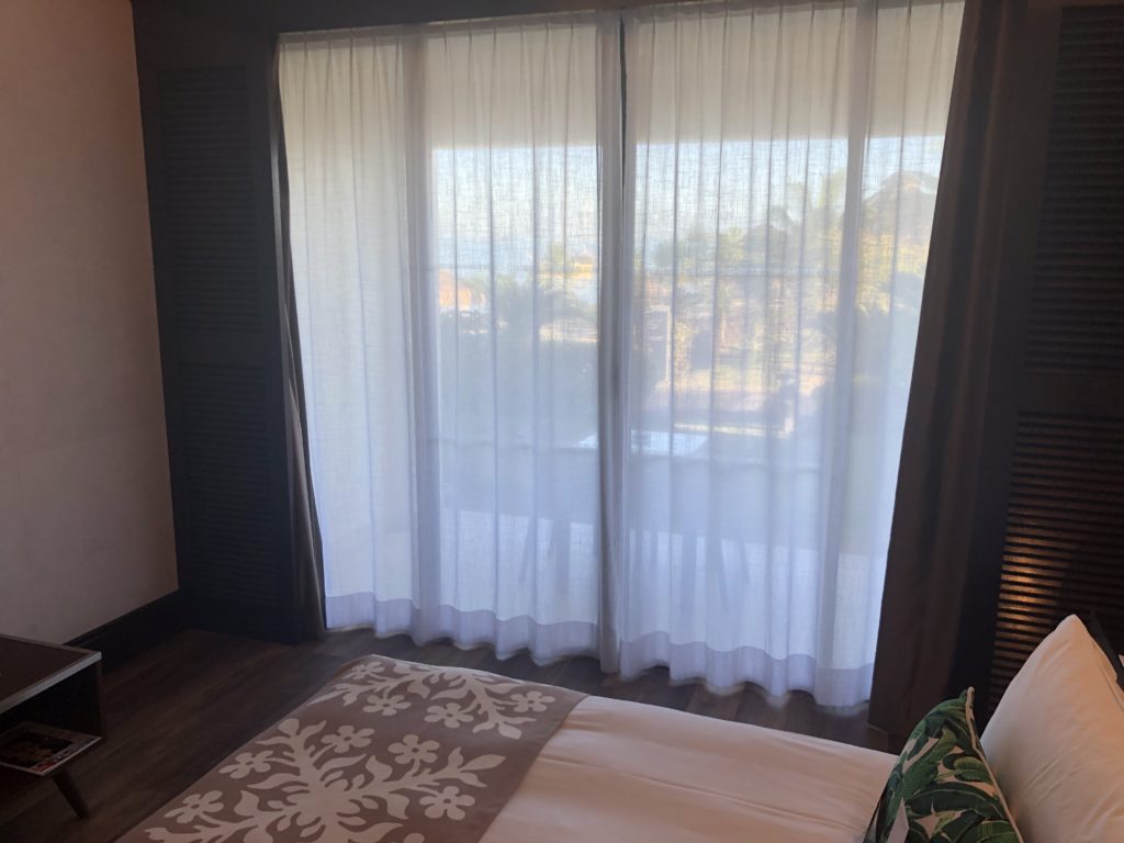 a bed with a pillow and curtains in a room