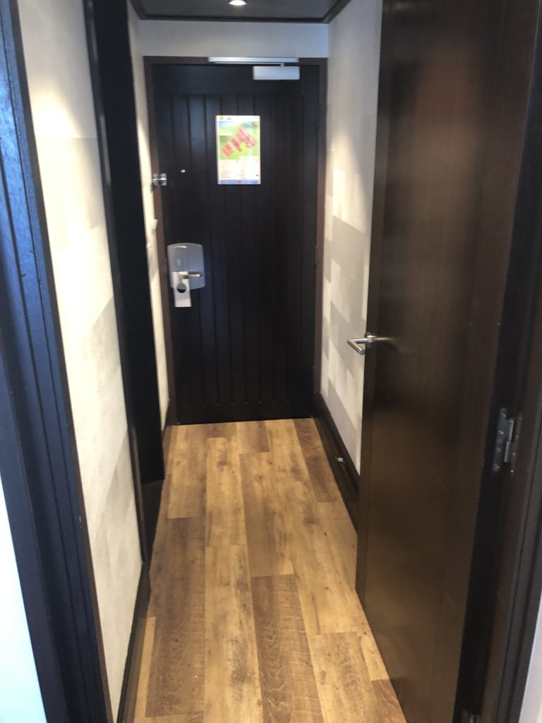 a hallway with a door and a wood floor
