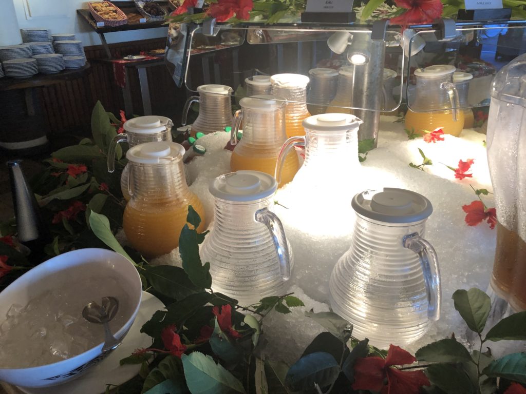 a group of glass jugs with orange juice in it