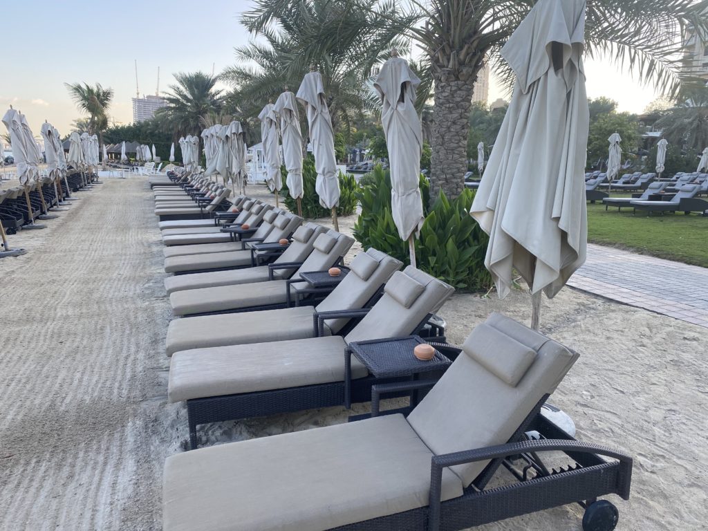 a row of lounge chairs on a beach