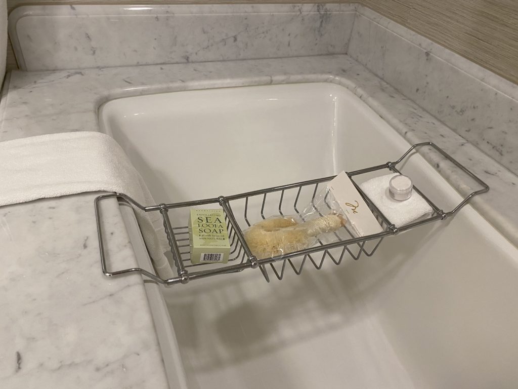 a bathtub with a soap holder and a towel