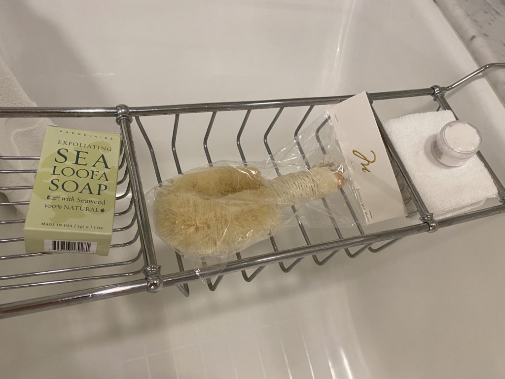 a bathtub with a bath brush and soap