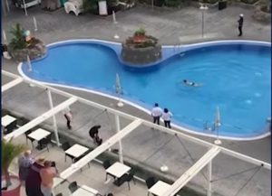 a pool with people standing around