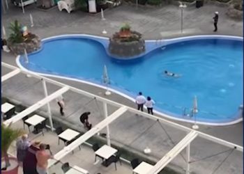 a pool with people standing around