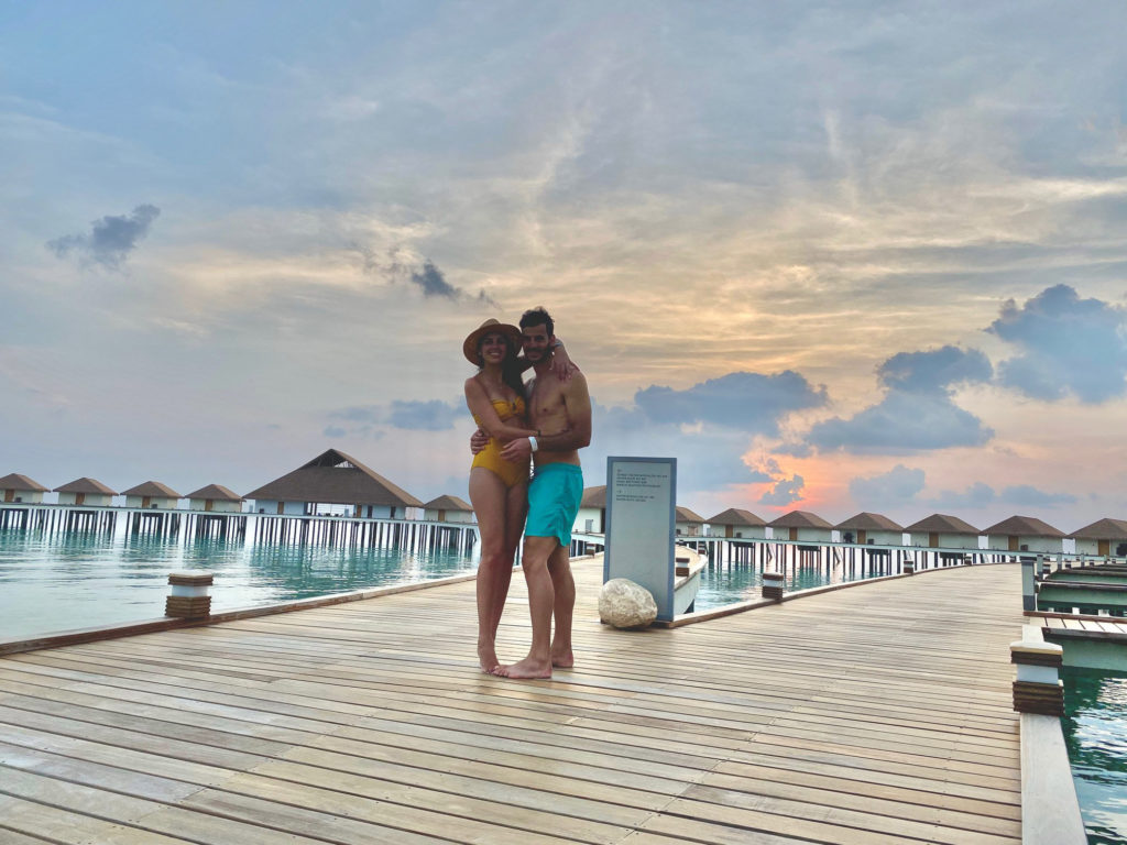a man and woman hugging on a dock