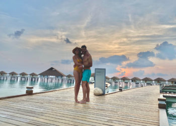a man and woman hugging on a dock