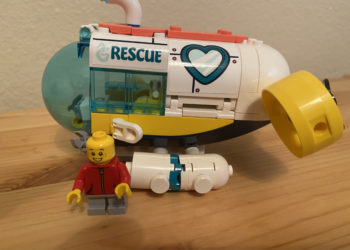 a toy submarine with a man standing next to it