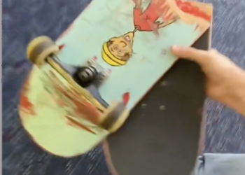a hand holding a skateboard
