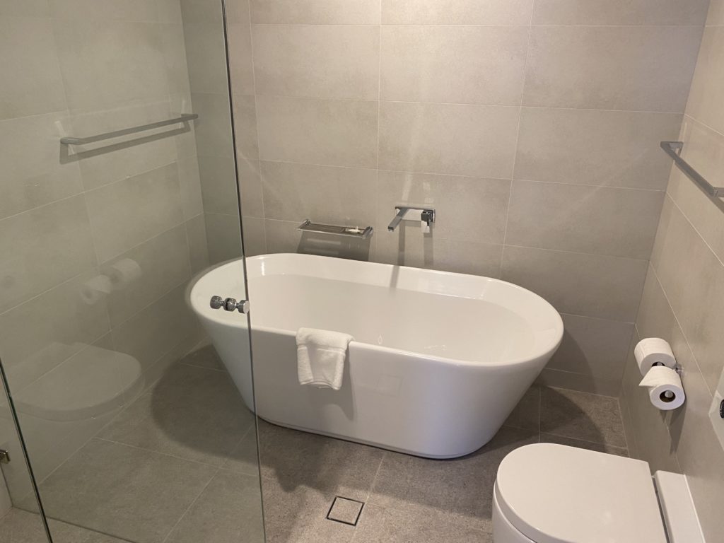 a bathroom with a tub toilet and shower