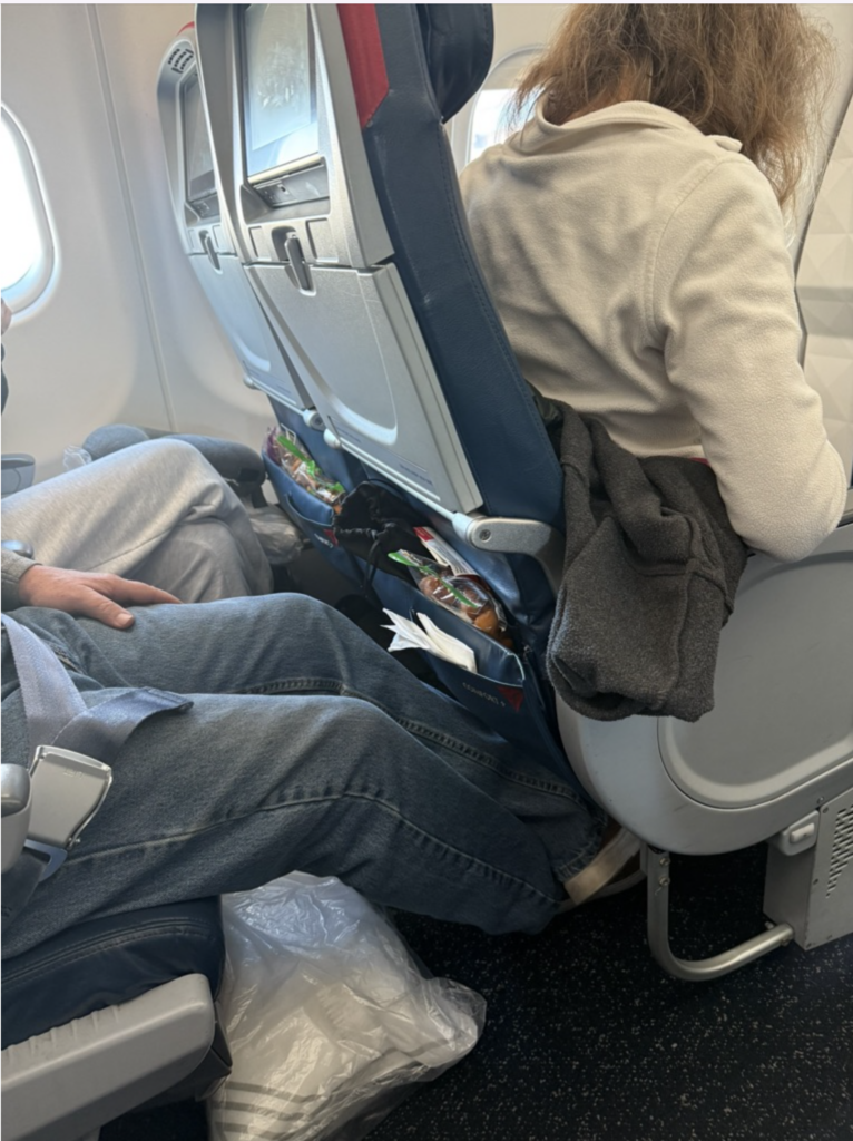 a man and woman sitting in an airplane